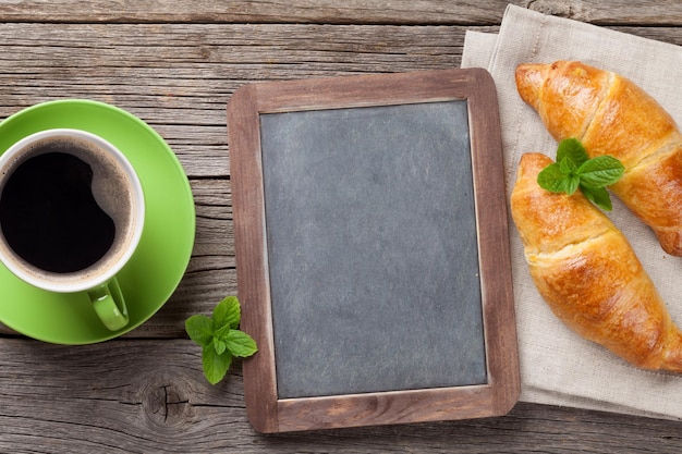 Foto blackboard croissants en koffiekop top view met kopieerruimte