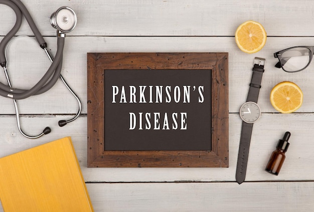 Blackboard met tekst Parkinson's disease boek stethoscoop en horloge