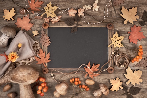 Blackboard omlijst met herfstdecoraties op houten ruimte