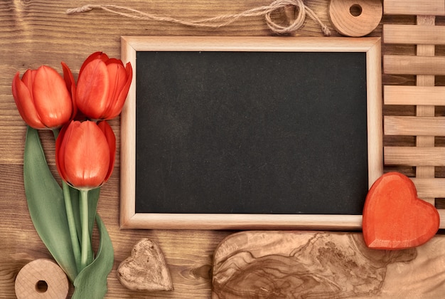 Foto blackboard omlijst met rode tulpen