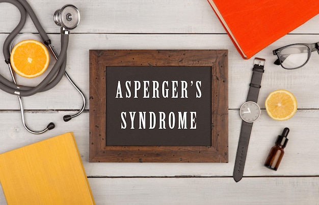텍스트 아스퍼거 증후군 책이 있는 칠판 청진기 안경 및 시계