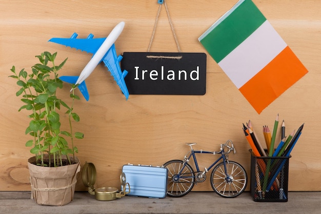 Blackboard with text Ireland flag of the Ireland airplane model little bicycle and suitcase compass pencils