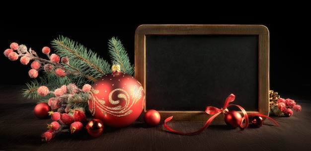 Blackboard with text space and Christmas decorations on black 