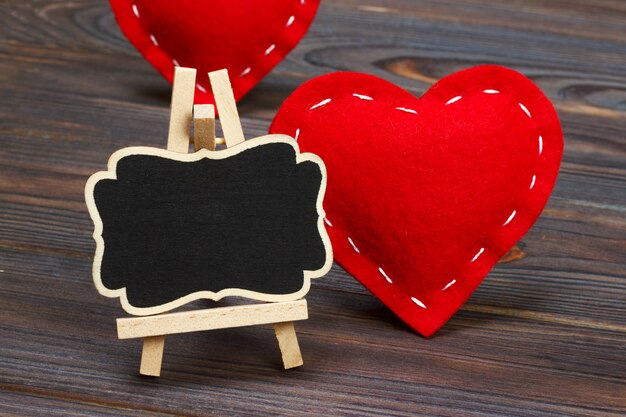 Blackboard on wooden background with red heart. 