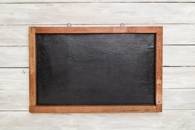 Blackboard in wooden frame on wooden wall