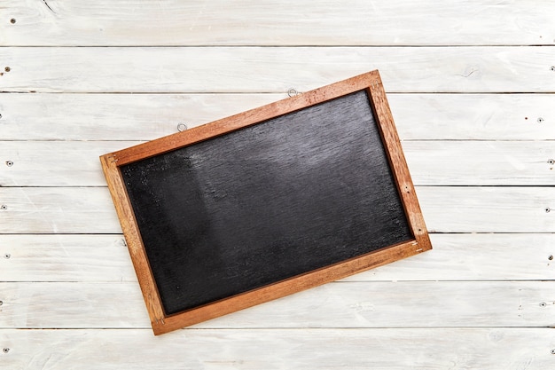 Blackboard in wooden frame on wooden wall