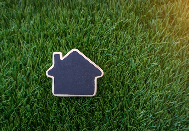 Blackboard wooden house placed on an artificial grass 