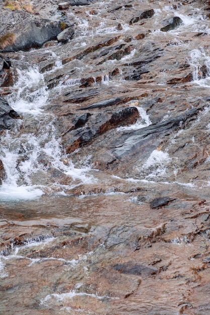 Foto texture di granito marrone cioccolato nero lavaggio di ruscelli alpini primo piano verticale valle di cogne aosta