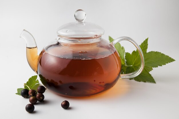 Blackcurrant tea in a transparent bowl on a light background