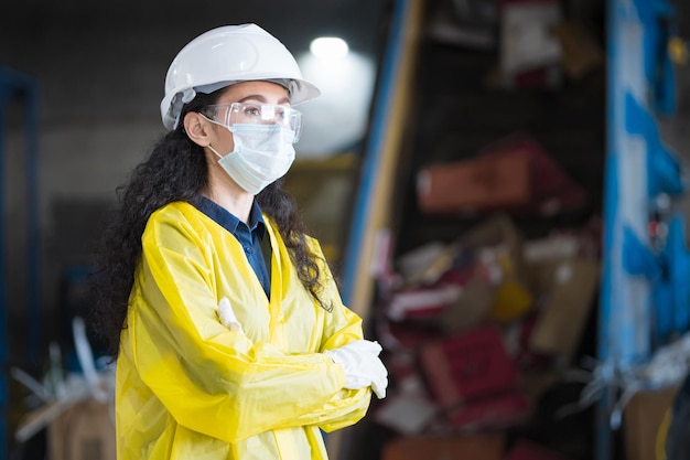 Blackhaired female inspector standing against conveyor belt