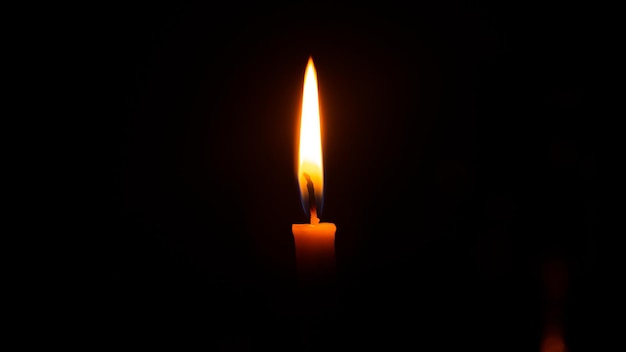 Giorno di blackout, quindi ecco una candelacandela fiamma a lume di candela sfondo nero scuro