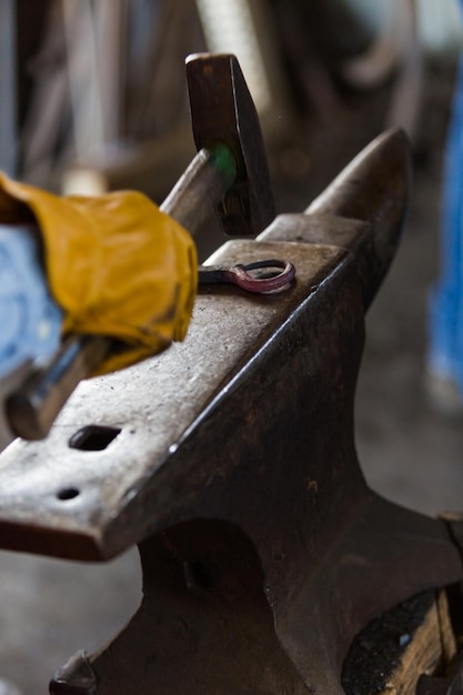 Blacksmith bending hot iron on the anvil.