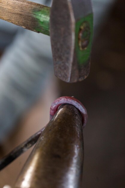 Blacksmith bending hot iron on the anvil.