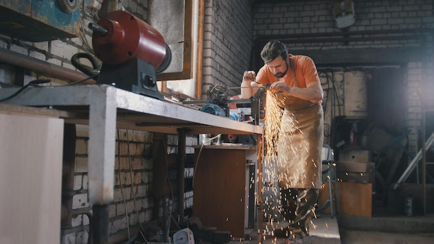 Blacksmith checks the thickness of the sharpening of a metal product