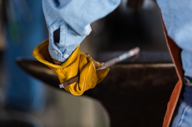 A blacksmith forging hot iron on the anvil.