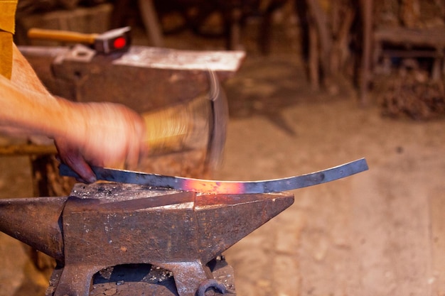 Blacksmith hammering a piece of molten iron