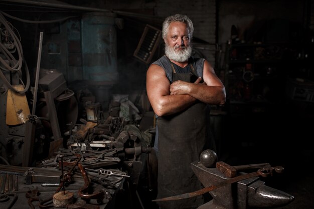 Photo blacksmith preparing to work metal on anvil