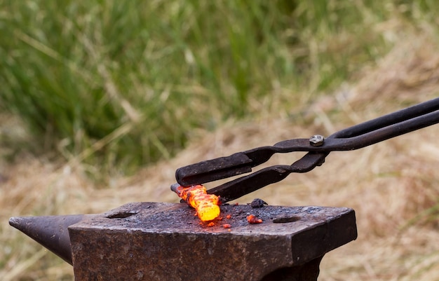 Blacksmith puts hot iron on an anvil for forging