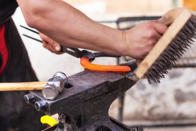 Blacksmith working on the anvil, making a horseshoe.