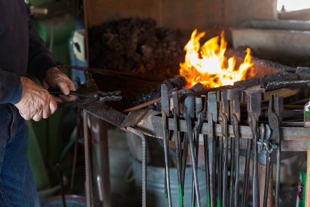 A blacksmith working at an old iron forge.