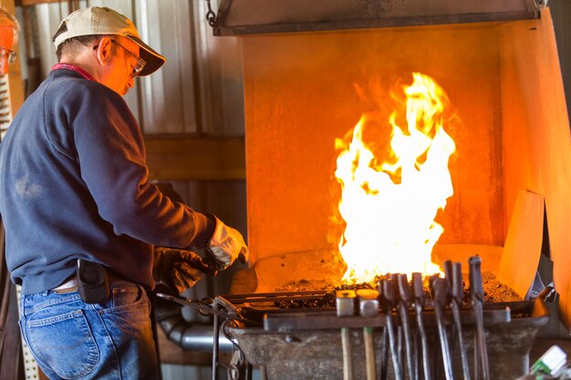 A blacksmith working at an old iron forge.