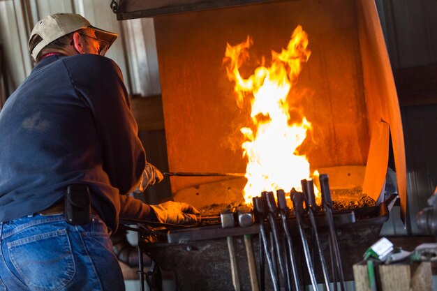 A blacksmith working at an old iron forge.