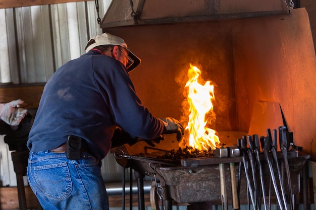 A blacksmith working at an old iron forge.