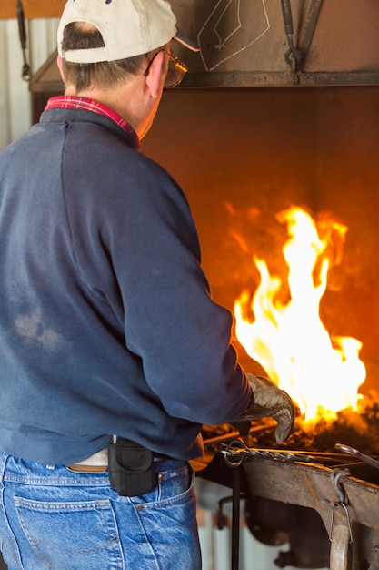 A blacksmith working at an old iron forge.