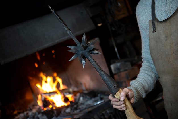 Photo blacksmiths hand with an ancient war swatch