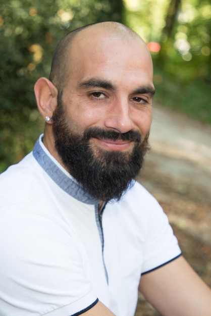 Blad knappe man met baard buiten glimlachend gelukkig kijkende kant