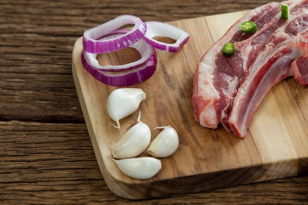Blade chop, uien en knoflook op een houten bord