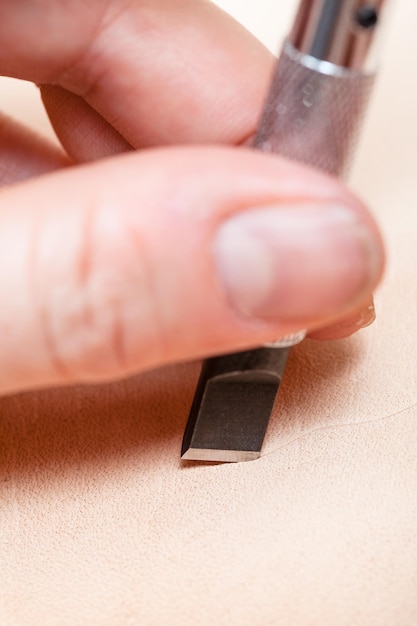 Blade of swivel knife cut leather close up