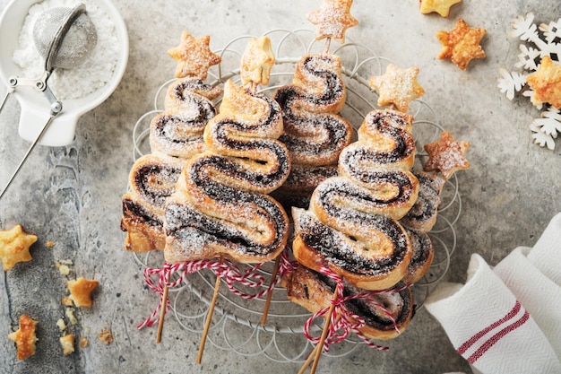 Bladerdeegcakes in de vorm van een kerstboom met chocoladevulling, suikerpoeder en lolly's op oude witte houten achtergrond Kerstmis Nieuwjaar Voorgerecht Feestelijk idee voor Kerstmis of Nieuwjaarsdiner