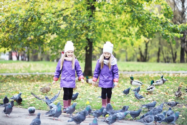 Bladval in het park. Kinderen voor een wandeling in het herfstpark. Familie. Val. Blijheid.