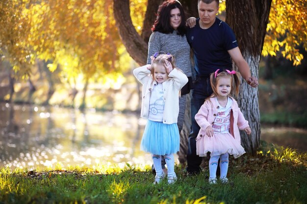 Bladval in het park. Kinderen voor een wandeling in het herfstpark. Familie. Val. Blijheid.