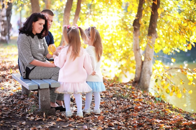 Bladval in het park. Kinderen voor een wandeling in het herfstpark. Familie. Val. Blijheid.