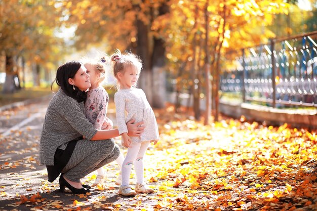 Bladval in het park. Kinderen voor een wandeling in het herfstpark. Familie. Val. Blijheid.