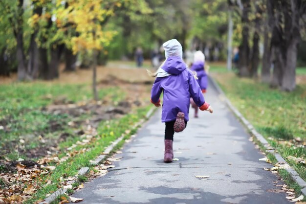 Bladval in het park. kinderen voor een wandeling in het herfstpark. familie. val. blijheid.