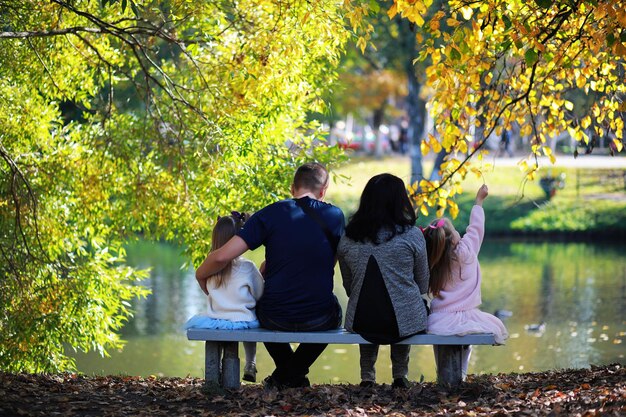 Bladval in het park. Kinderen voor een wandeling in het herfstpark. Familie. Val. Blijheid.