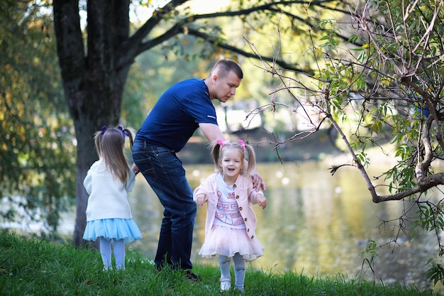 Bladval in het park. Kinderen voor een wandeling in het herfstpark. Familie. Val. Blijheid.