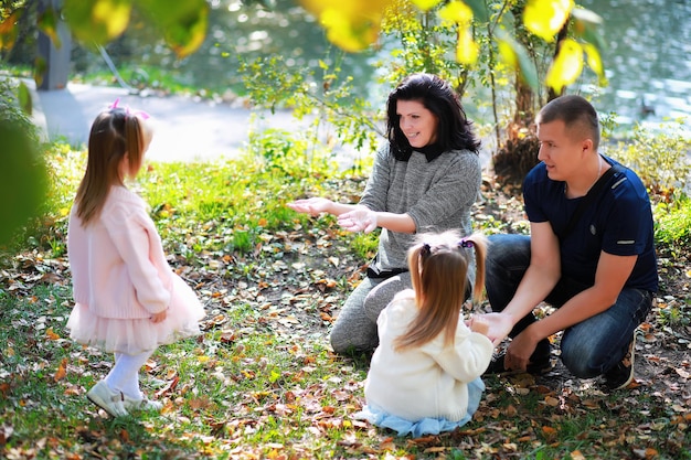 Bladval in het park. Kinderen voor een wandeling in het herfstpark. Familie. Val. Blijheid.