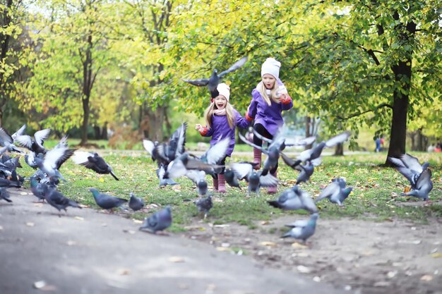 Bladval in het park Kinderen voor een wandeling in het herfstpark Family Fall Happiness