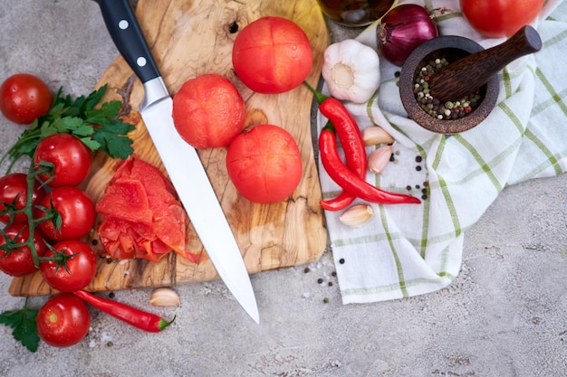 Blanched peeled tomatoes on wooden cutting board at domestic kitchen