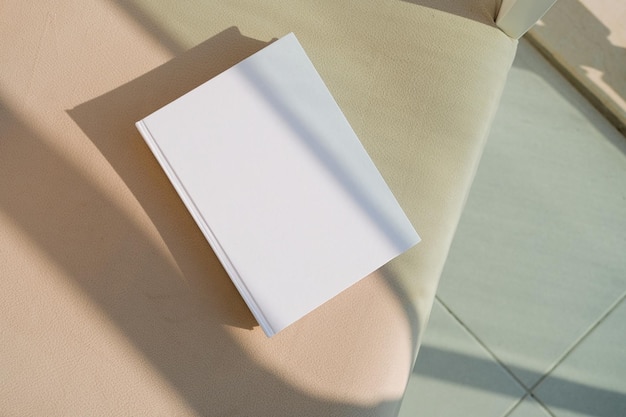 blanco boek mockup op zachte fauteuil op terras of balkon buiten schaduw overlay