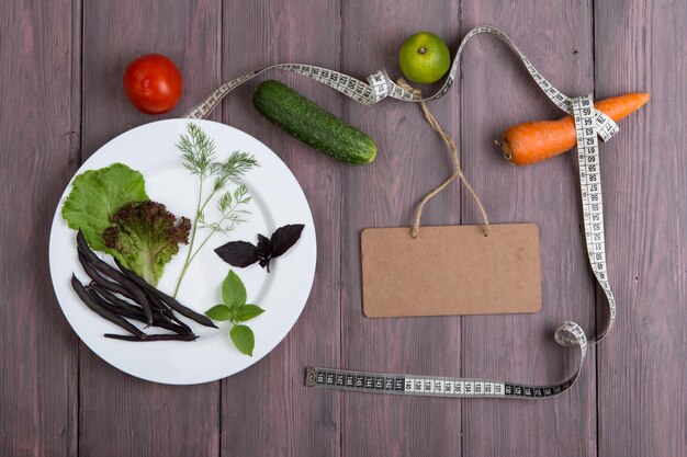 Blanco bord meetlint witte plaat met blad van salade komkommer tomaat en andere groenten