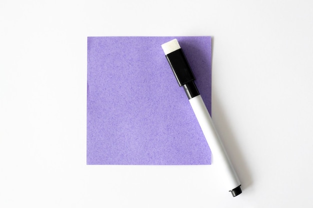 Foto blanco briefhoofd mockup van paars plaknotitiepapier op de witte tafel naast de markering lay-out van plaknotitiepapier blanco vel voor notities bovenaanzicht