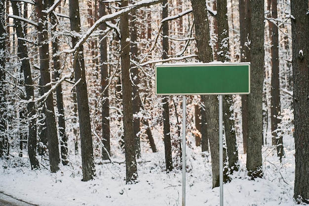 Blanco groen verkeersbord in de winter Ontwerpsjabloon voor informatieposten in de buurt van een snelweg in de winter