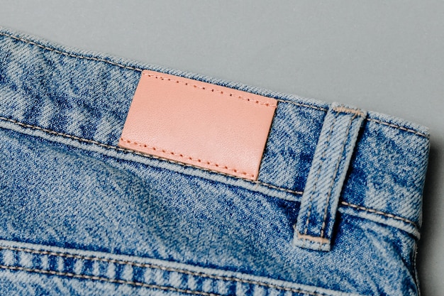 Foto blanco lederen jeans label genaaid op een spijkerbroek. mock-up