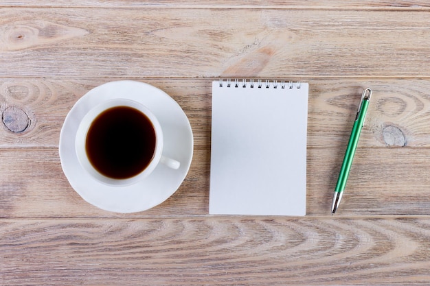 Blanco notitieblok en potlood met kopje koffie op kantoor houten tafel achtergrond Bedrijfsconcept met kopieerruimte voor elk ontwerp