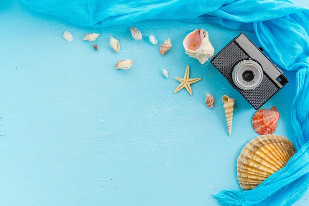 Blanco papier fotolijst met zeesterren, schelpen en items op houten tafel.